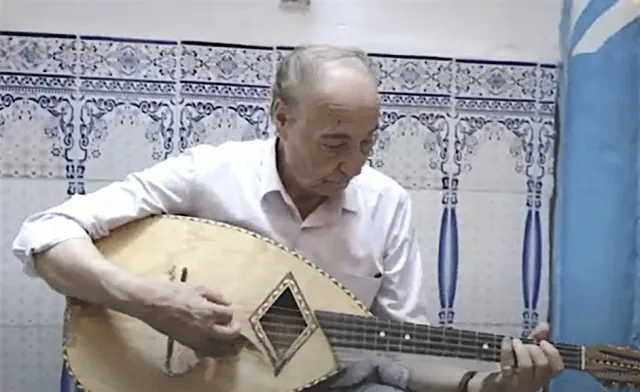 Musicien jouant d’un instrument à cordes dans un intérieur aux faïences décorées